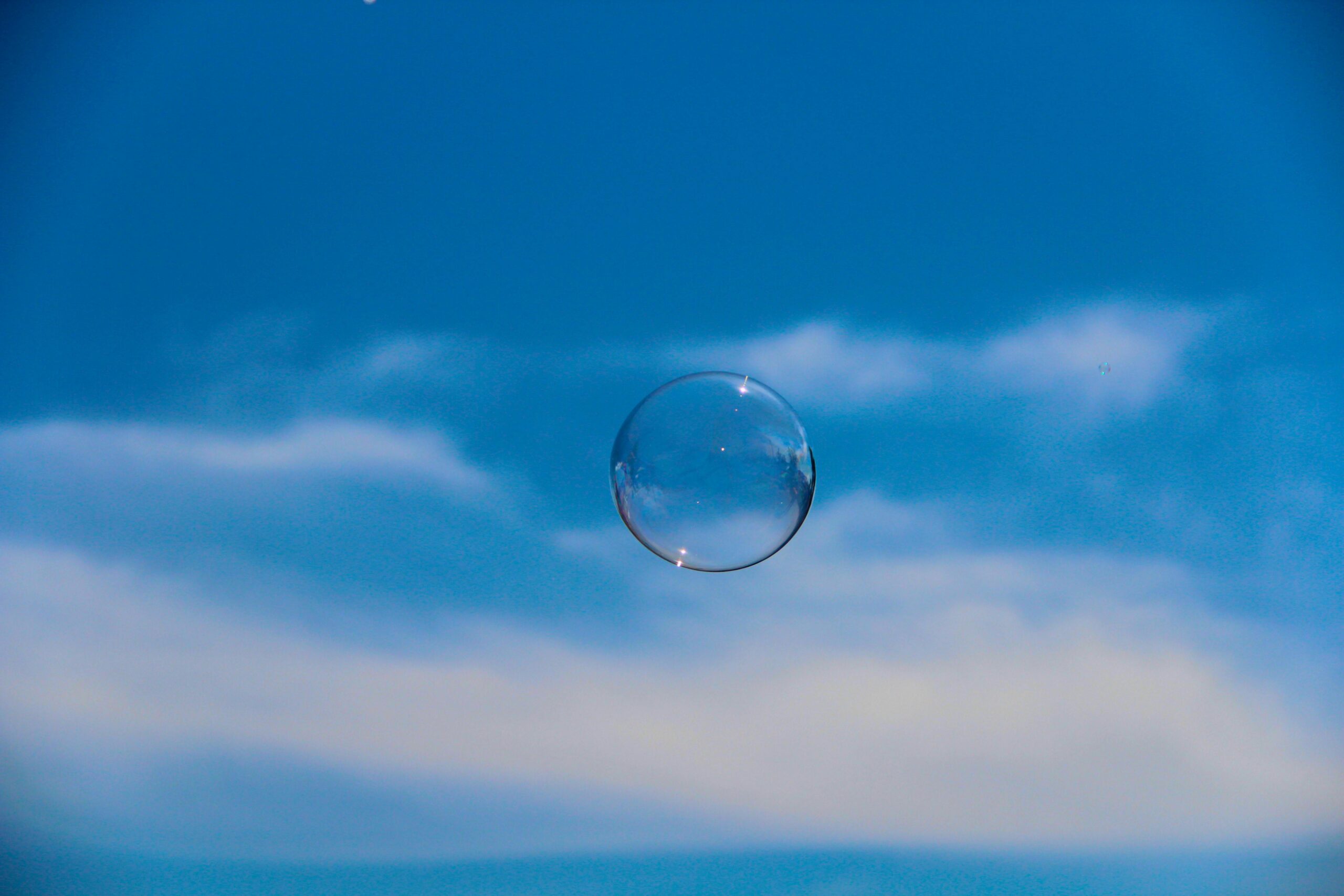 bubble 1 Clear soap bubble floating against a blue sky with soft clouds, symbolizing clarity and transparency in legal services like estate planning and conveyancing.