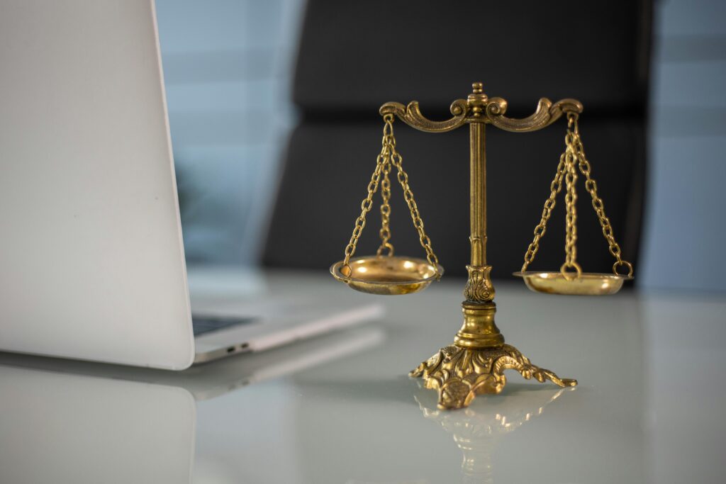 Executor Law - How Your Marriage Contract Affects Your Estate Golden Justice Scale next to a Laptop