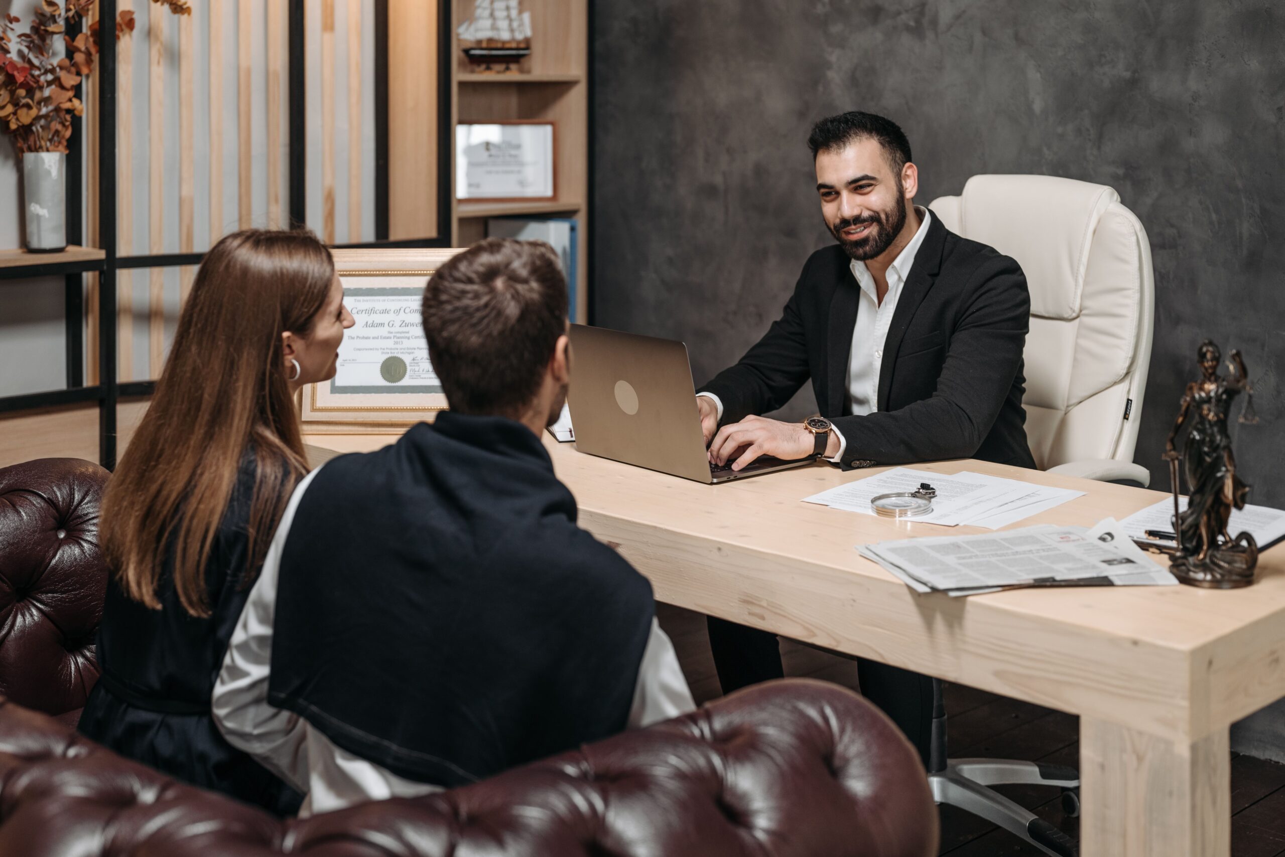 Executor Law - How an Antenuptial Contract Protects Assets from Creditors A Notary sitting across from a Couple in a Professional Consultation setting, reviewing Documents together.