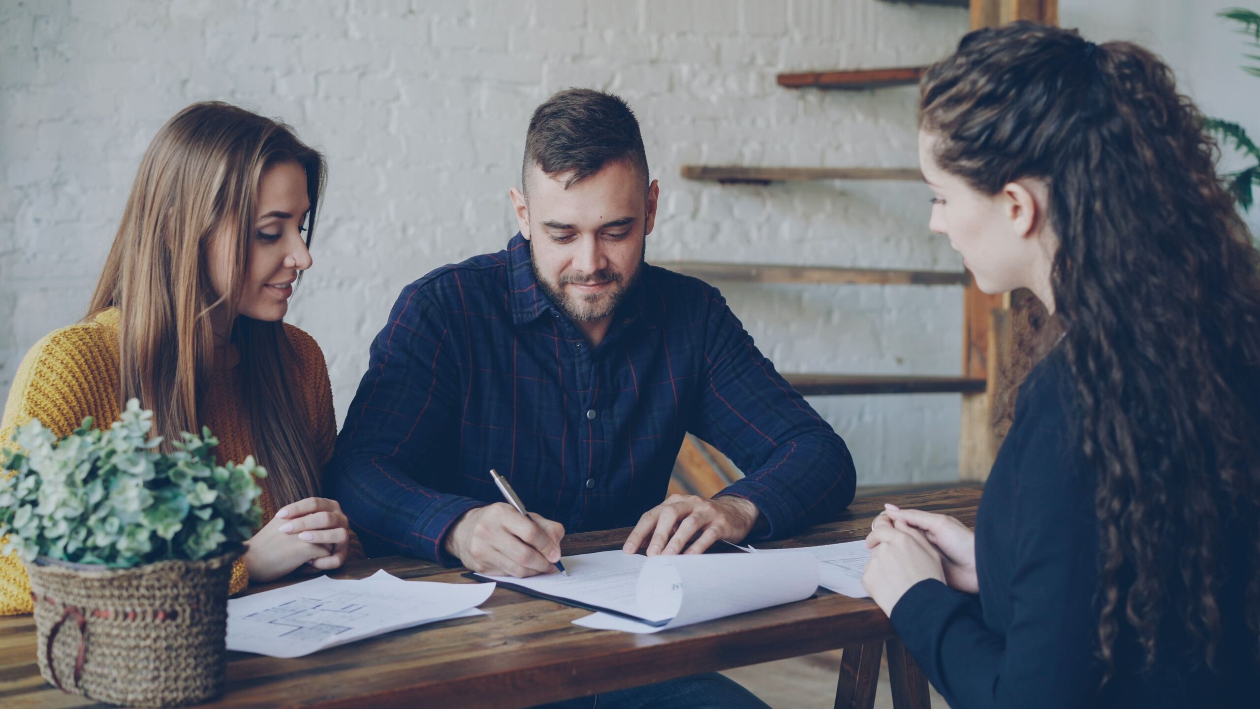 Executor Law - How an Antenuptial Contract Protects Assets from Creditors A Couple signing an Antenuptial Contract together at a table with a Notary present.