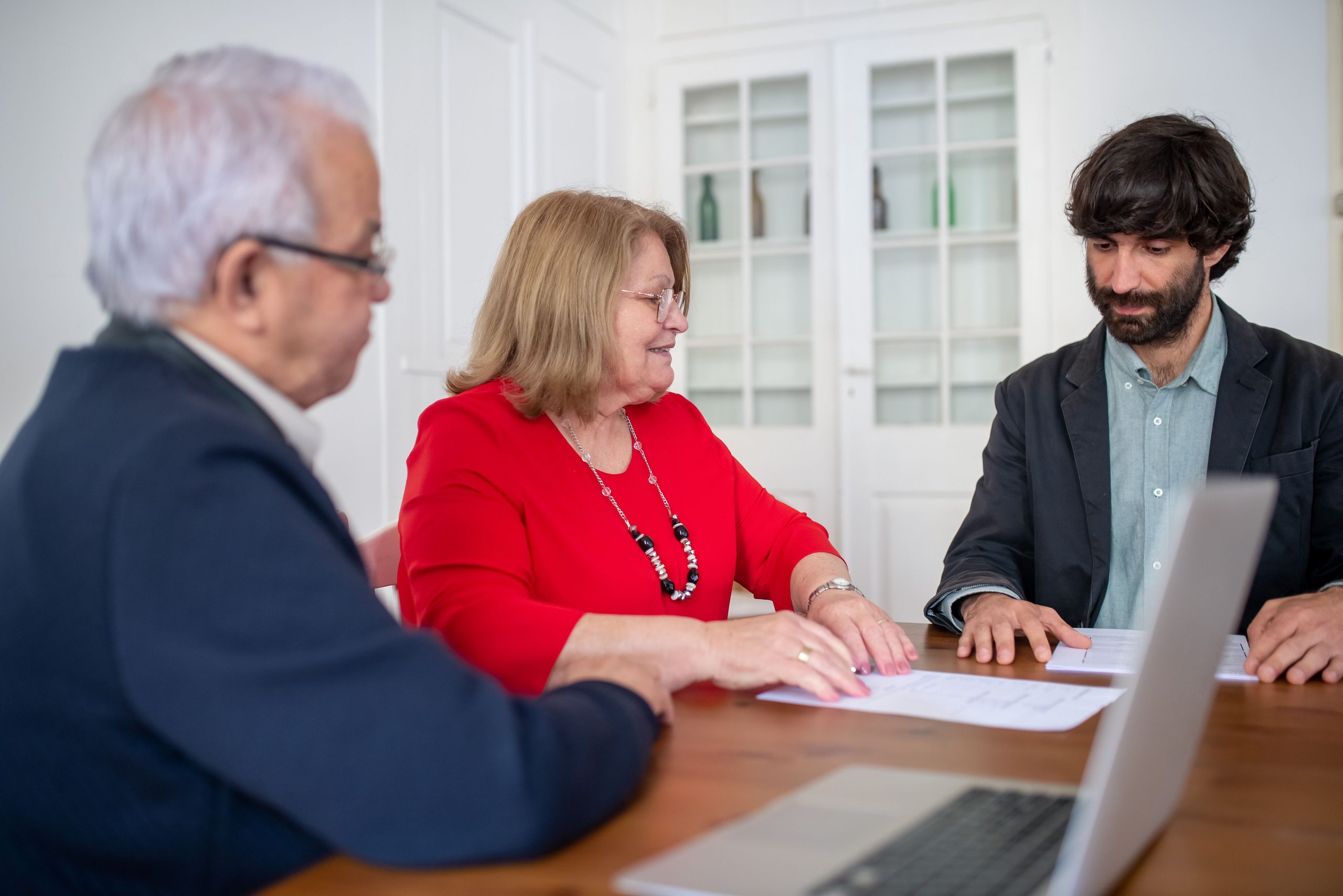 Conveyancer reviewing property documents with clients at a desk.